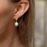Sea shell earrings with pearls modelled against long dark blond hair