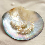 Petal Keshi pearls on gold vermeil hoops from RAW Copenhagen resting here on a sea shell