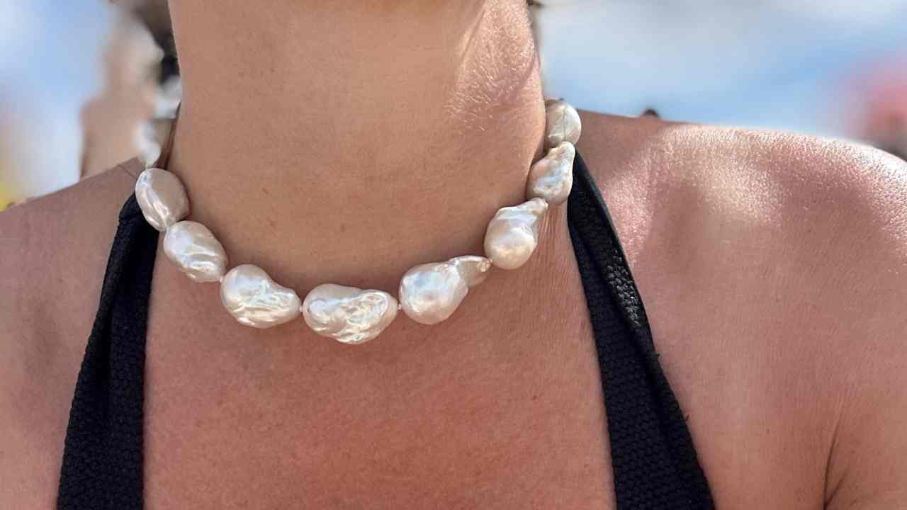 Stunning big baroque freshwater pearl choker necklace modelled against a block top in the sun, the big pearls rests beautifully on the models collarbone