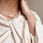 Baroque pearl and labradorite choker modelled against a cream silk dress