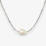 Baroque pearl and labradorite choker handing against a cream background