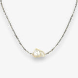 Baroque pearl and labradorite choker handing against a cream background