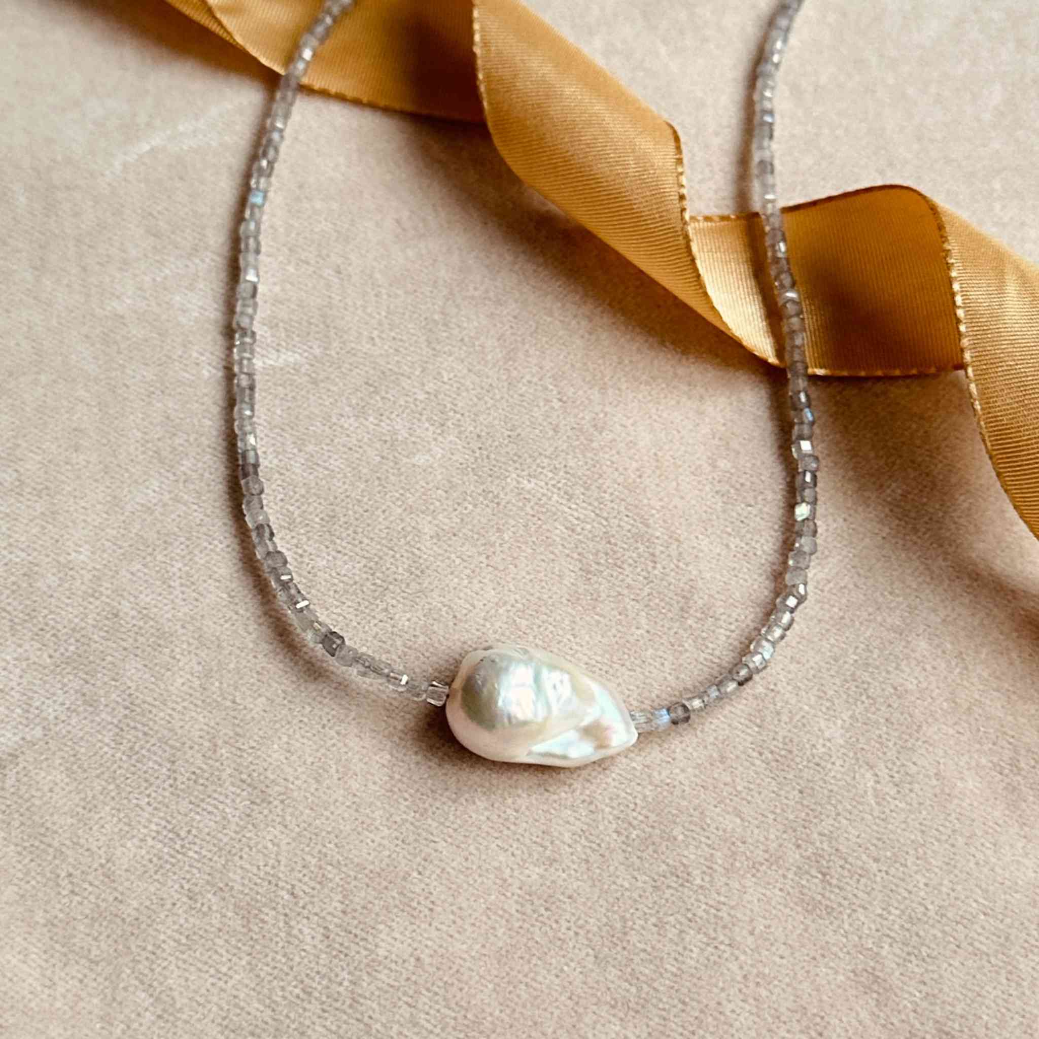 Baroque pearl and labradorite choker laying on a velvet backdrop.jpg