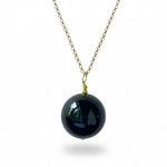 A gold chain necklace featuring a large, glossy black onyx pendant shown against a plain white background