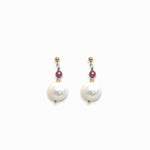 Pair of pearl earrings with pink ruby gemstones on a white background
