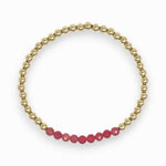Gold bracelet with pink rhodochrosite beads on a white background