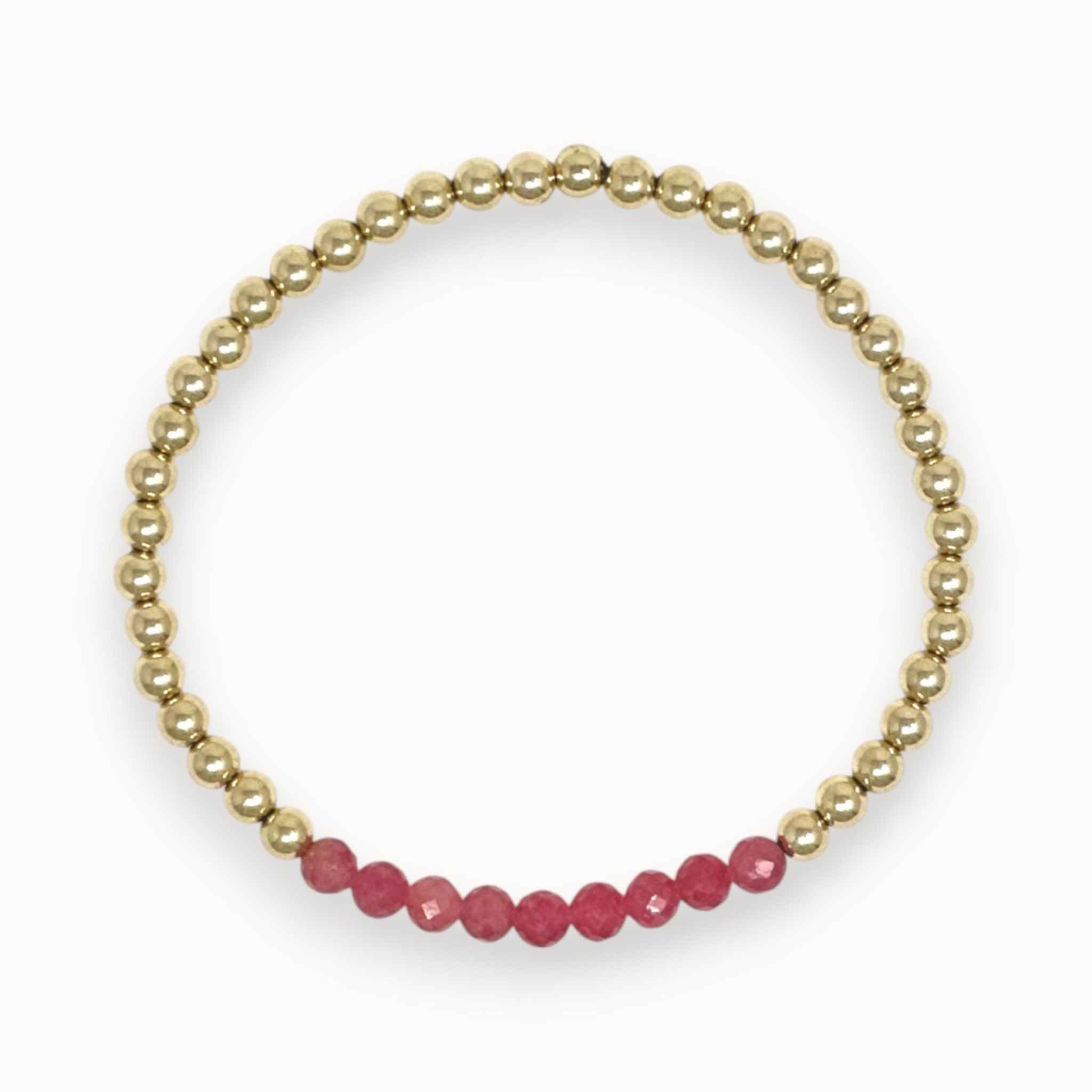 Gold bracelet with pink rhodochrosite beads on a white background