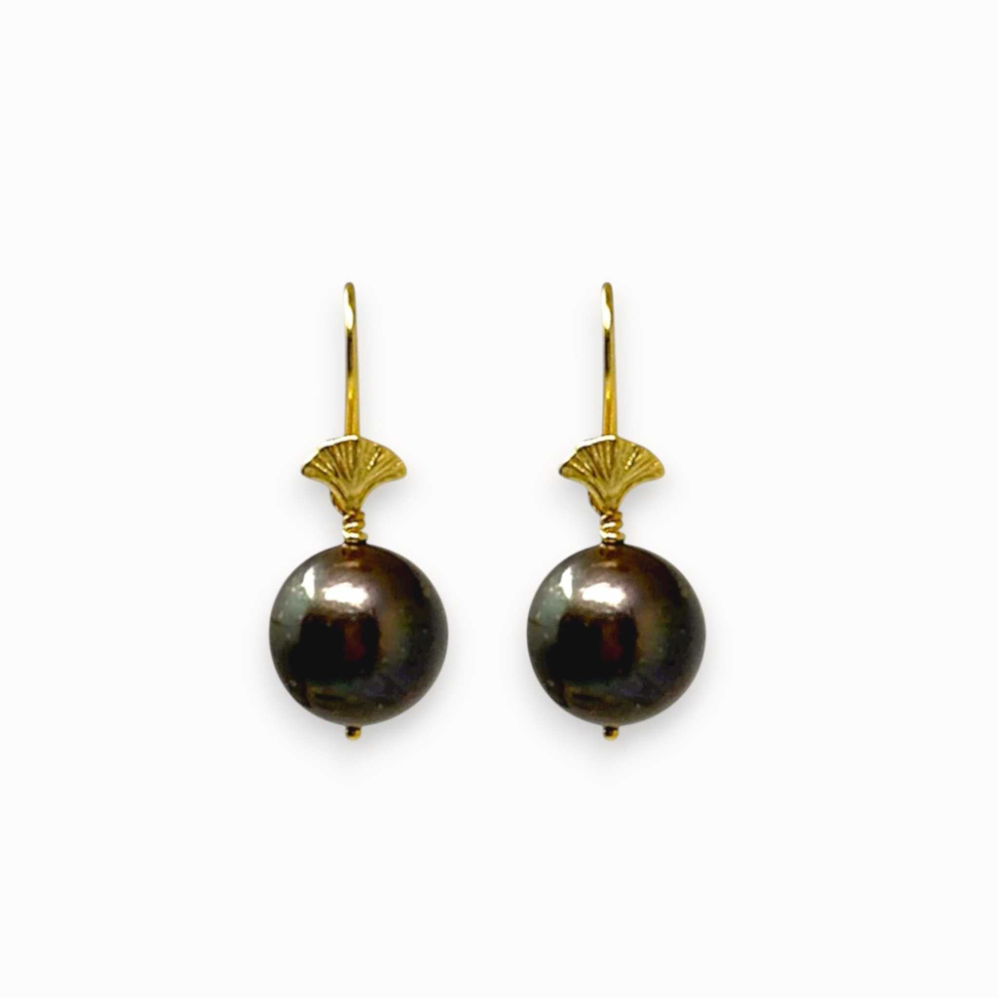 Pair of black pearl earrings with gold hooks on a white background