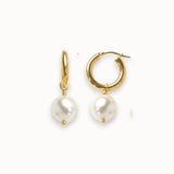 Gold hoop earrings with white pearls on a white background