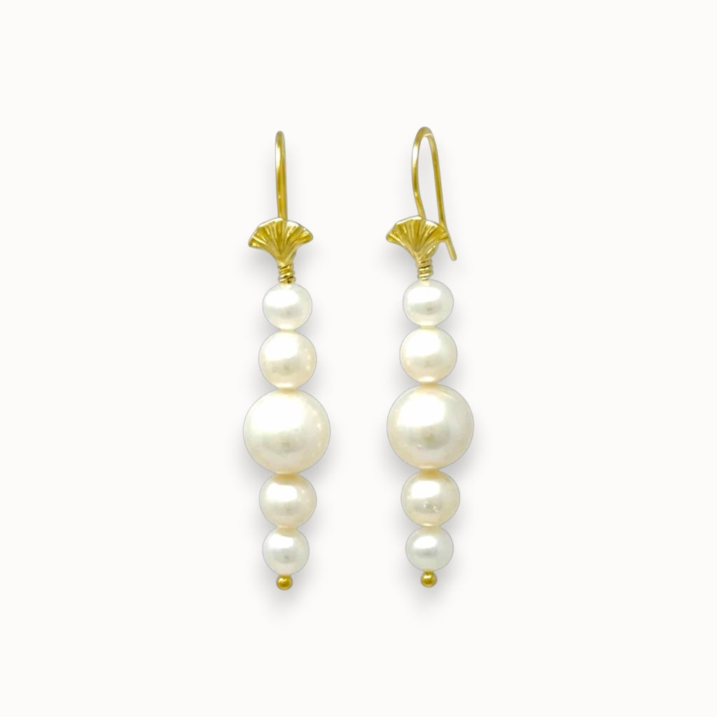 Pair of pearl earrings with gold hooks on a white background