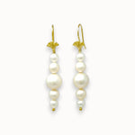 Pair of pearl earrings with gold hooks on a white background