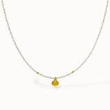 Delicate pearl Necklace with a gold shell pendant on a white background