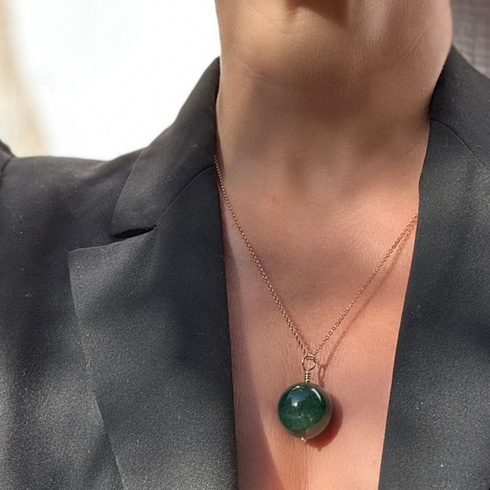 Green onyx pendant necklace styled with a black blazer