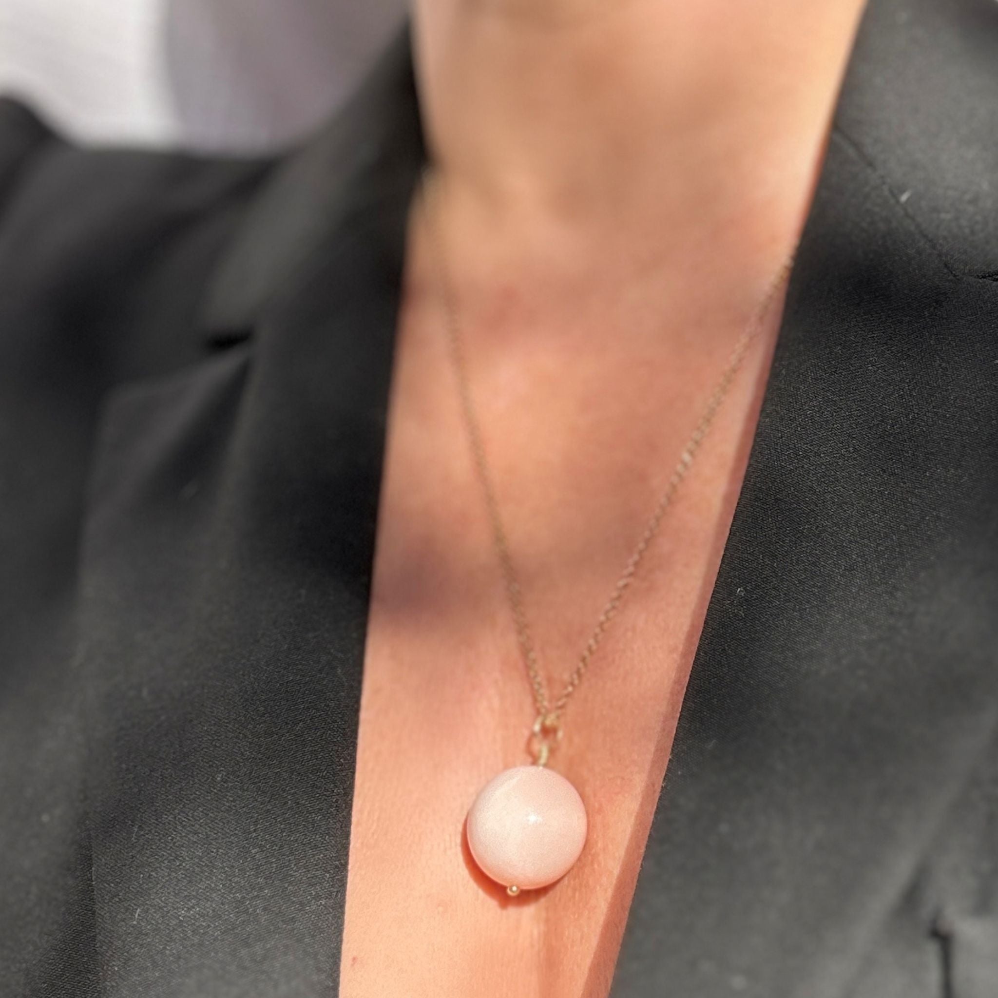 Pink agate pendant necklace styled with a black blazer
