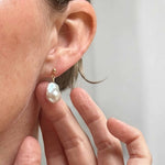 Pearl earring being worn with a blurred background