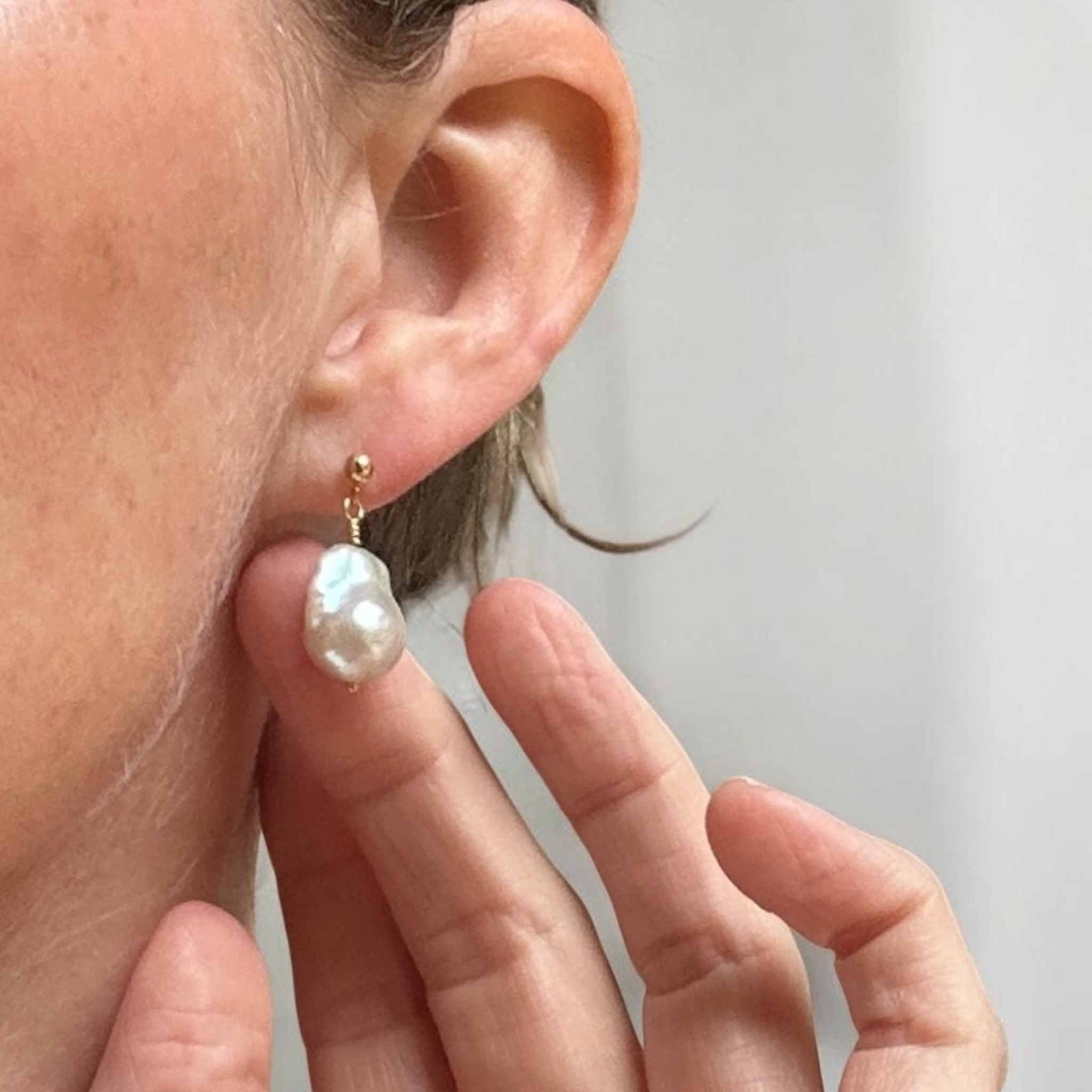 Pearl earring being worn with a blurred background
