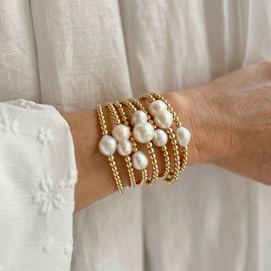 14k gold-filled baroque pearl bracelet by RAW Copenhagen, shown stacked with other freshwater pearl bracelets