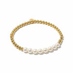 Gold beaded bracelet with white pearls on a white background