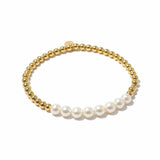 Gold beaded bracelet with white pearls on a white background