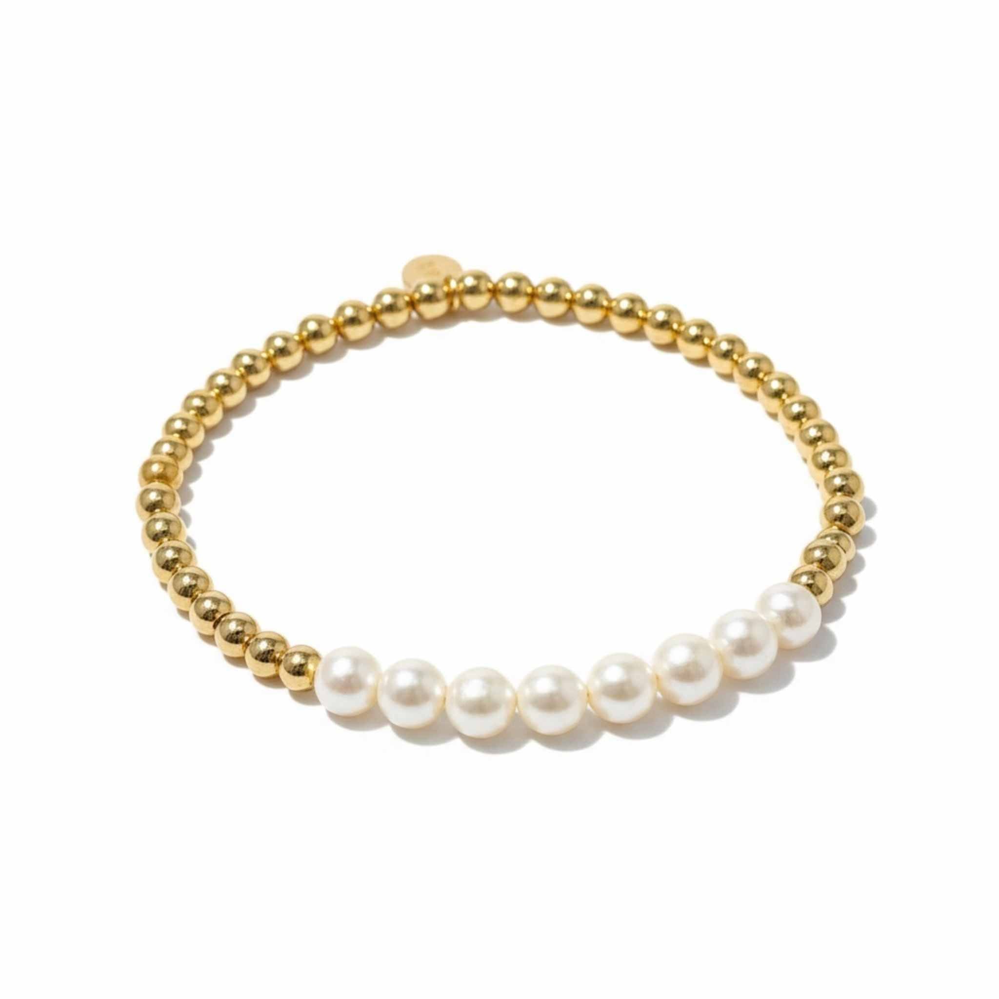 Gold beaded bracelet with white pearls on a white background