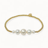 Pearl bracelet with gold beads on a white background
