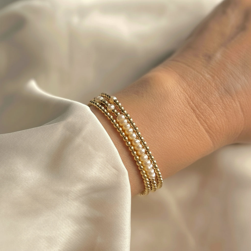 gold wrap bracelet with pearls worn with a cream silk wedding dress