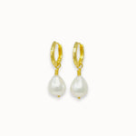 Gold hoop earrings with pearl drops on a white background