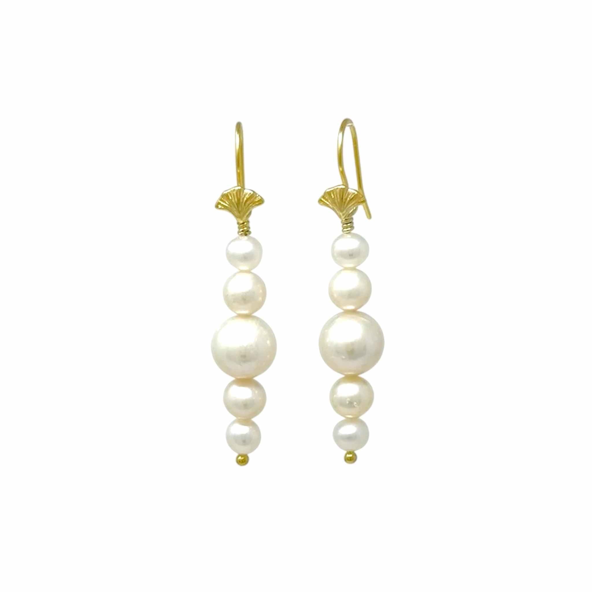 Pair of pearl earrings with gold hooks on a white background