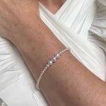 Pearl bracelet on a person's wrist with a white background