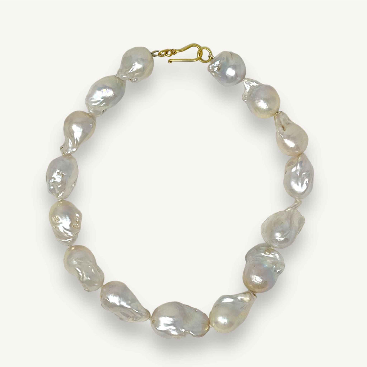 Large baroque pearl necklace resting on a neutral background