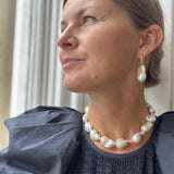 Large baroque Pearl necklace and earrings from RAW COpenhagen modelled with a blue Ulla JOhnson Dress