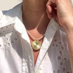 Gold Disc pendant on pearl necklace modelled
