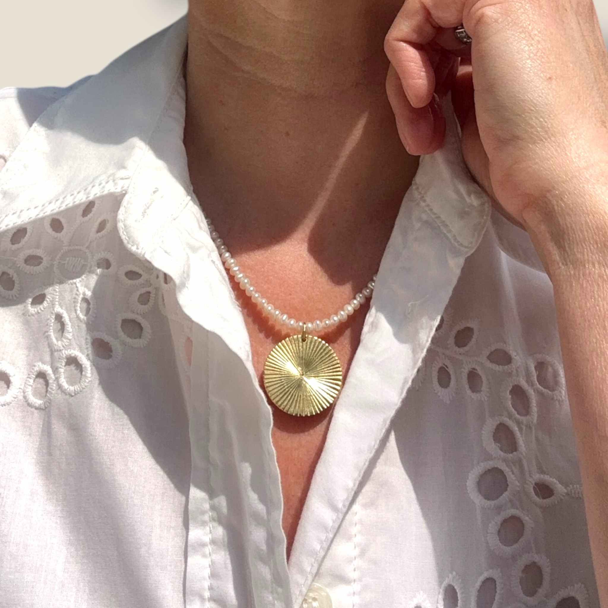Gold Disc pendant on pearl necklace modelled