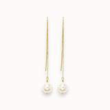 Pair of pearl earrings with gold chains on a white background