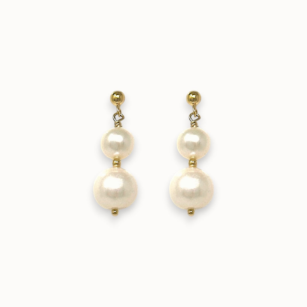 Pair of pearl earrings with gold accents on a white background
