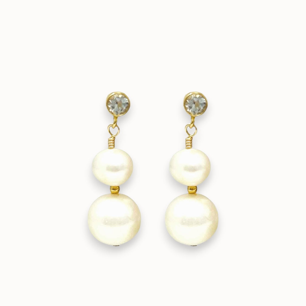 Pair of pearl earrings with gold accents on a white background