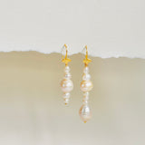 Stunning Scandinavian earring design with mismatched pearl drop on gold ear wire