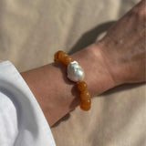 Red aventurine and baroque pearl statement bracelet modelled