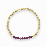 Gold bracelet with purple beads on a white background