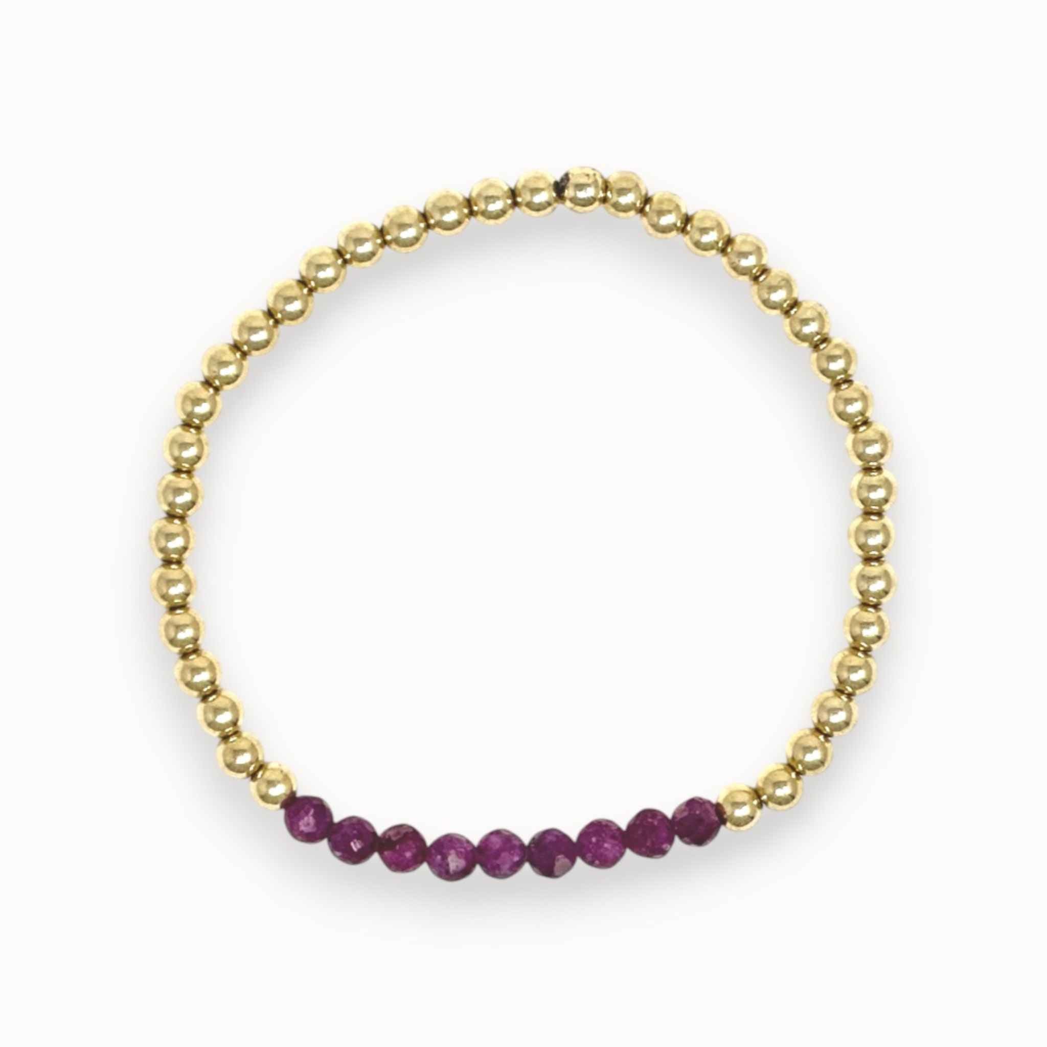 Gold bracelet with purple beads on a white background