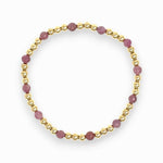 Six mauve ruby and gold beaded bracelet on white background