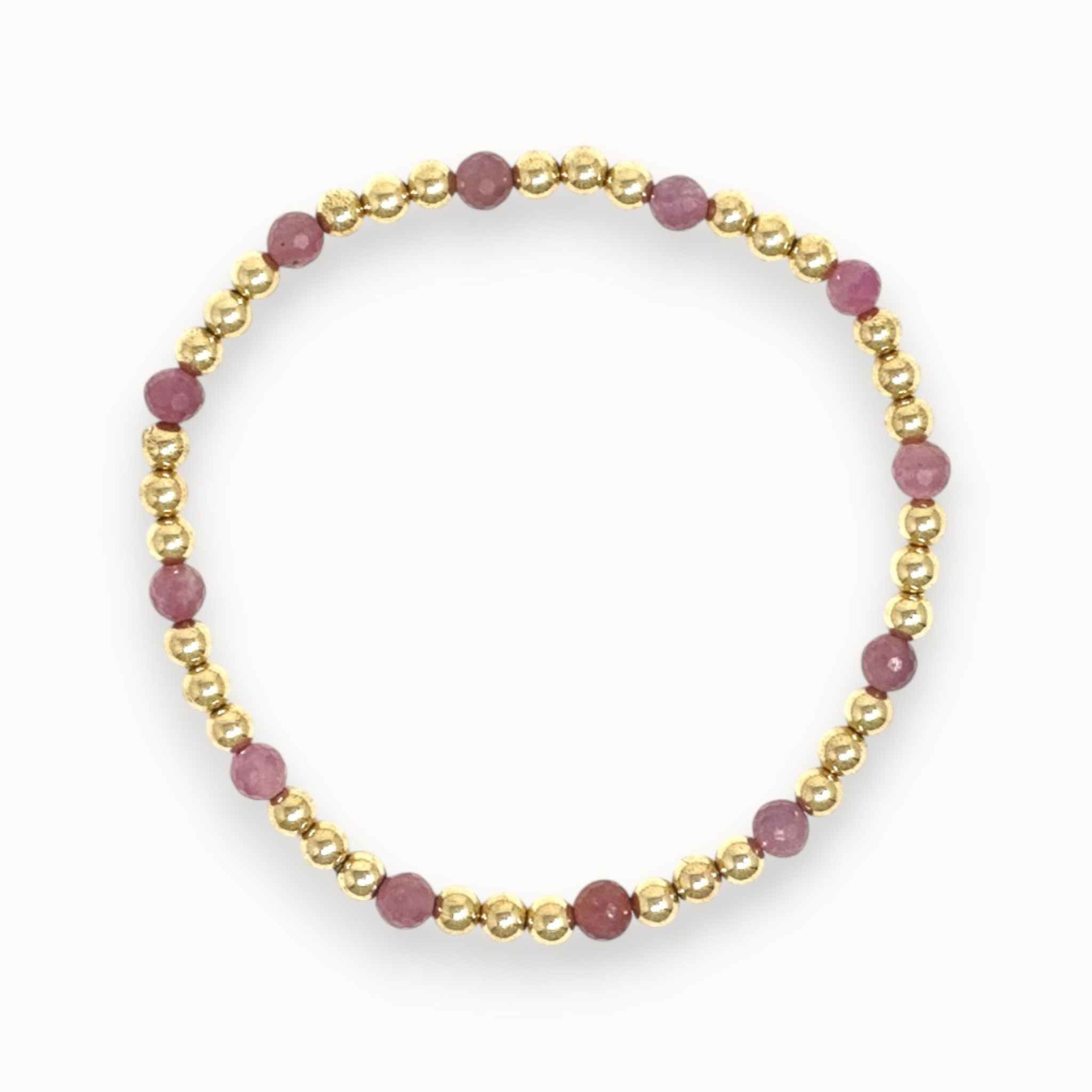 Six mauve ruby and gold beaded bracelet on white background