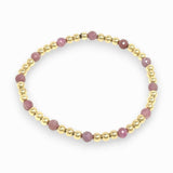 Bracelet with pink ruby beads and gold accents on a white background