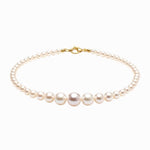 Pearl bracelet with gold clasp on a white background