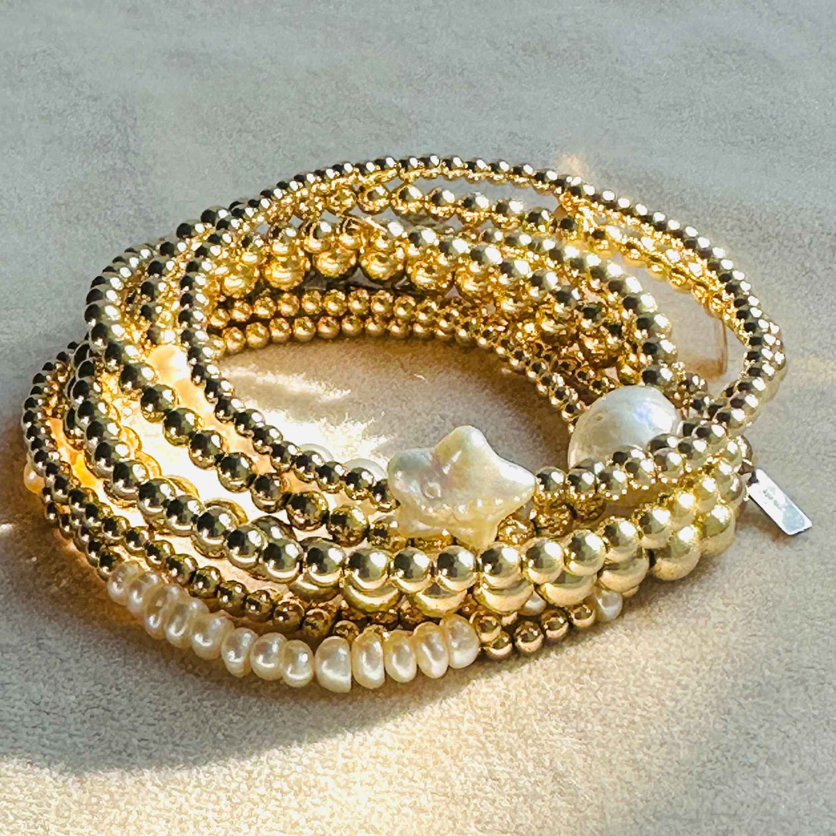 Stack of 14 karat gold filled beads, some with freshwater pearls