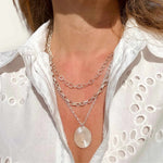 Sterling silver pendant and chain necklaces modelled against sun kissed skin and a white dress