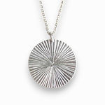 Silver circular pendant necklace on a white background