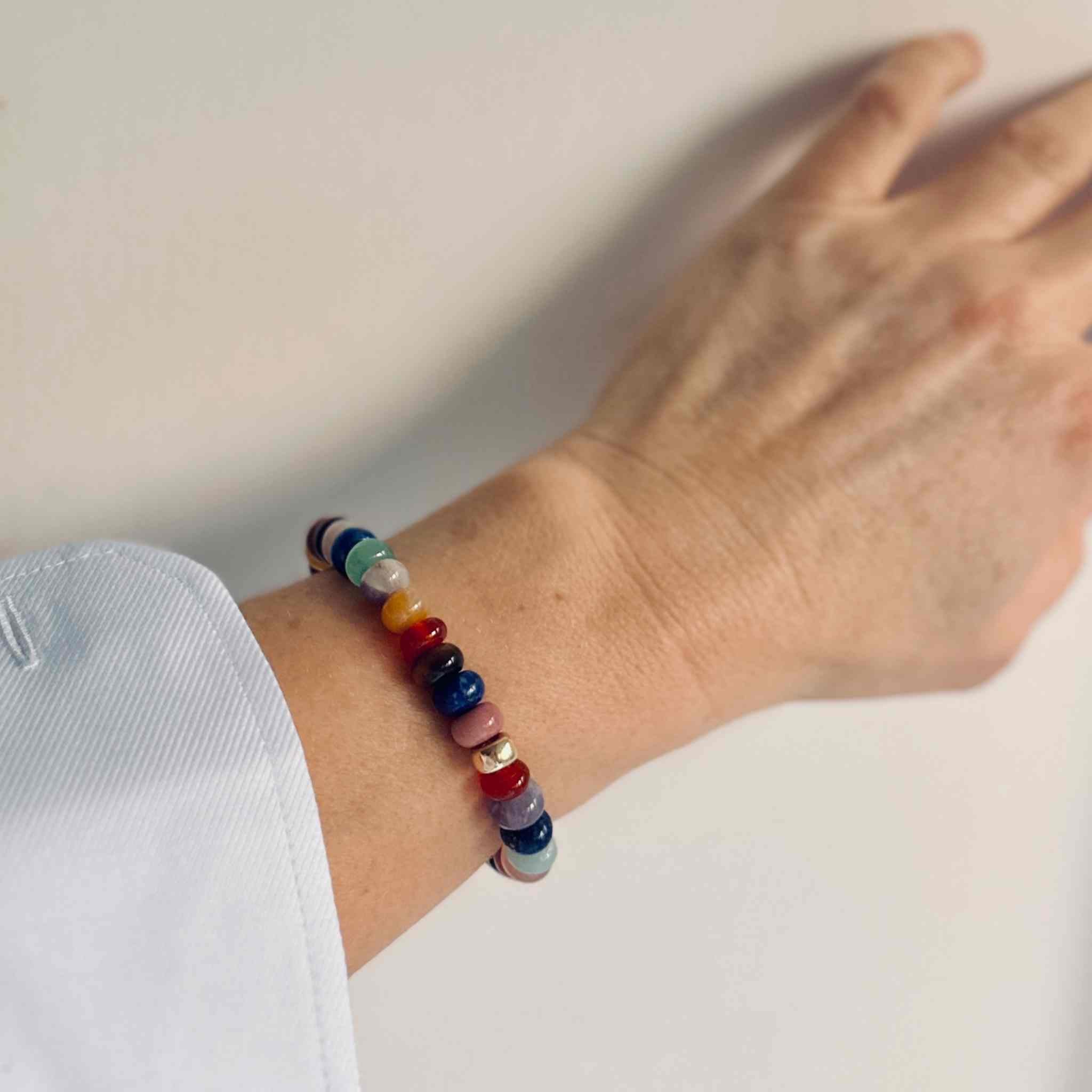 The RAW Charity Bracelet in Support of Amnesty International  with multicoloured gemstones modelled with white shirt