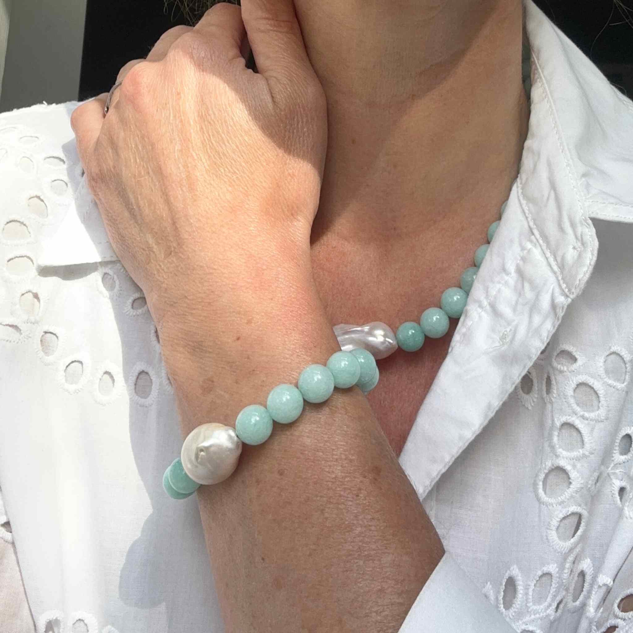 Turquoise Jade and Baroque Pearl Statement Bracelet modelled with matching necklace against a white broderie anglaise dress

