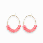 Gold hoop earrings with pink jade beads on a white background